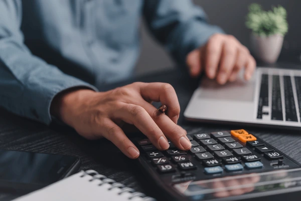 businessman using calculator bookkeeping payroll 600nw 2458502247